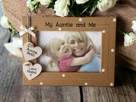 Image shows brown vintage my auntie and me photo frame, decorated with cream polka dots and two wooden hanging cream hearts for names, attached to string and cream bow.