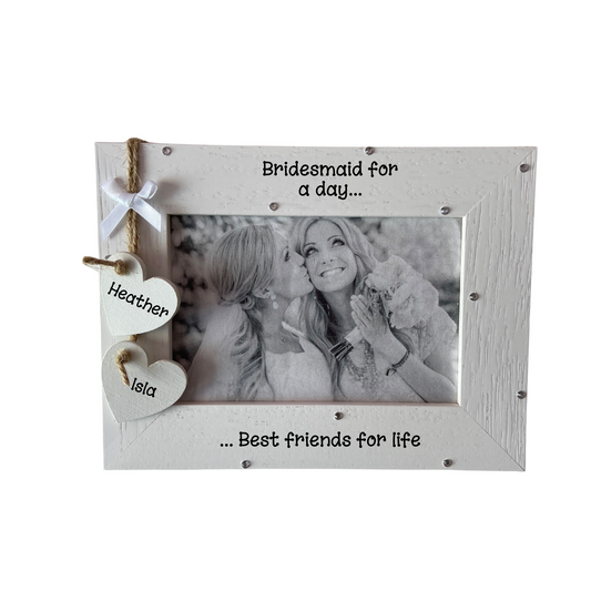 Image shows bride and bridesmaid frame, with two hanging hearts with names, also a small white bow above. Can also add bling if wanted.