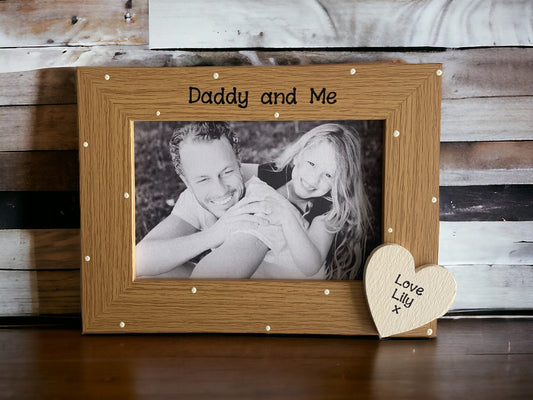 Image shows brown vintage daddy and me photo frame, decorated with cream polka dots and cream wooden heart with child's name.