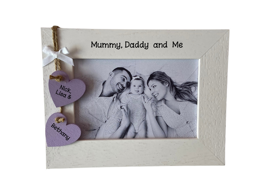 Image shows wooden family photo frame, consists of two hanging wooden hearts for parents and child's name, attached to small bow. Gems can be added.
