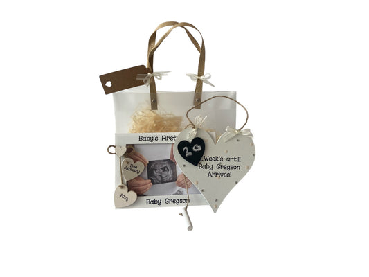 Image shows pairing baby's first scan photo frame and plaque, photo frame decorated with two hanging hearts for baby's due date with a smaller dotted heart above, plaque is decorated with a wooden heart, polka dots, bling and ribbon, attached is a piece of chalk so u can count down the days. Gift wrap and photo included.