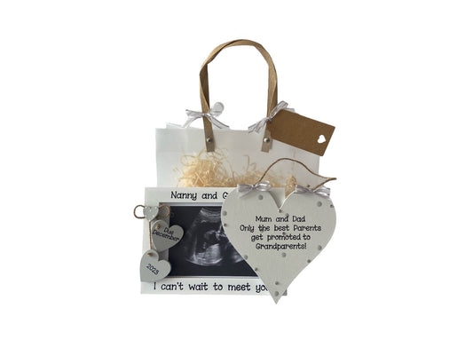 Image shows pairing photo frame and plaque for a grandparent announcement, photo frame has two hanging wooden hearts for due date, plaque is decorated with polka dots, bling and ribbon. Gift wrap and photo included.