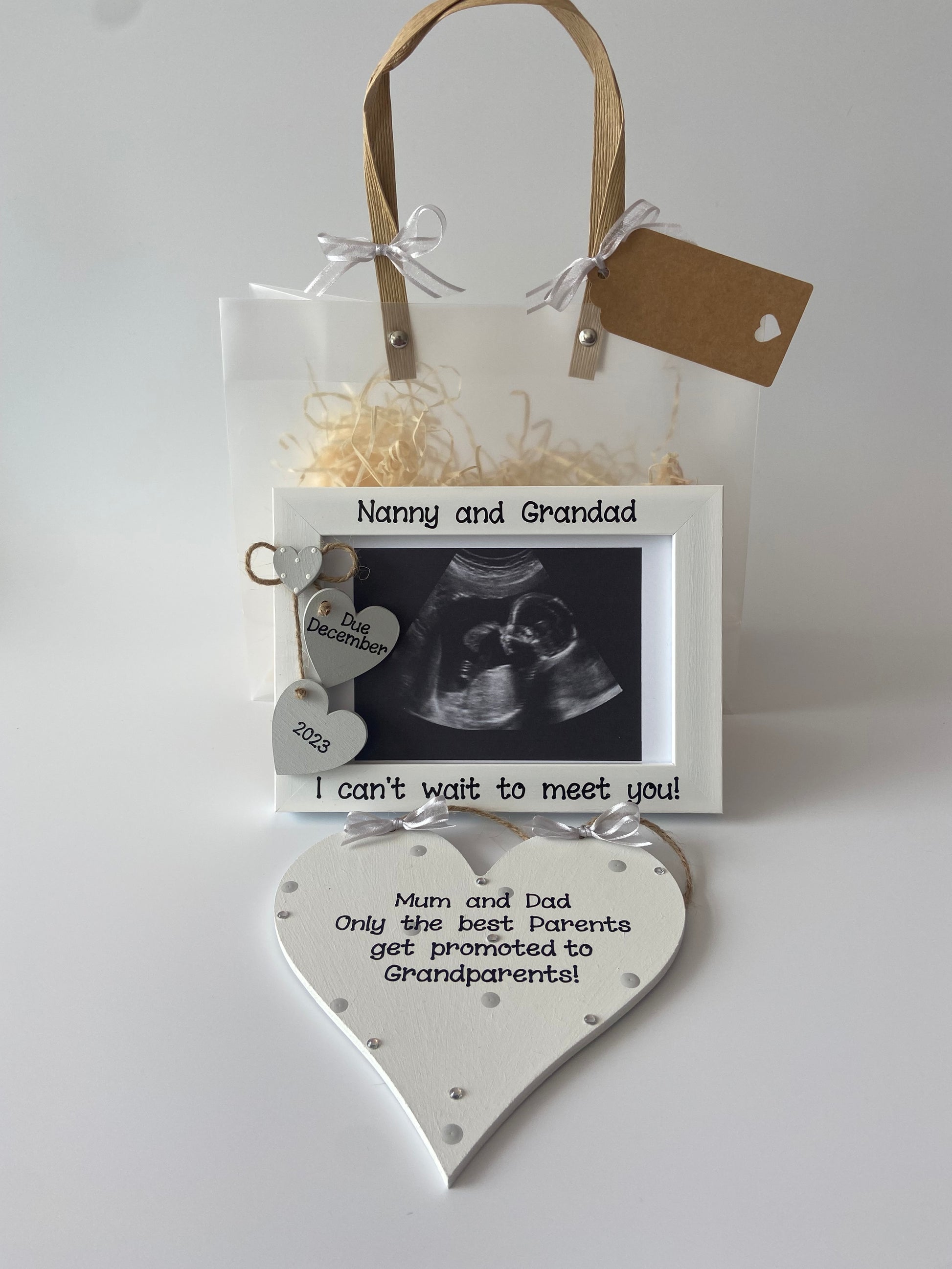 Image shows a gift set including a photo frame and plaque for new grandparents, plaque decorated with polka dots, gems and ribbon. Photo frame includes two hearts with baby's due date. Includes gift wrap and your scan photo. 