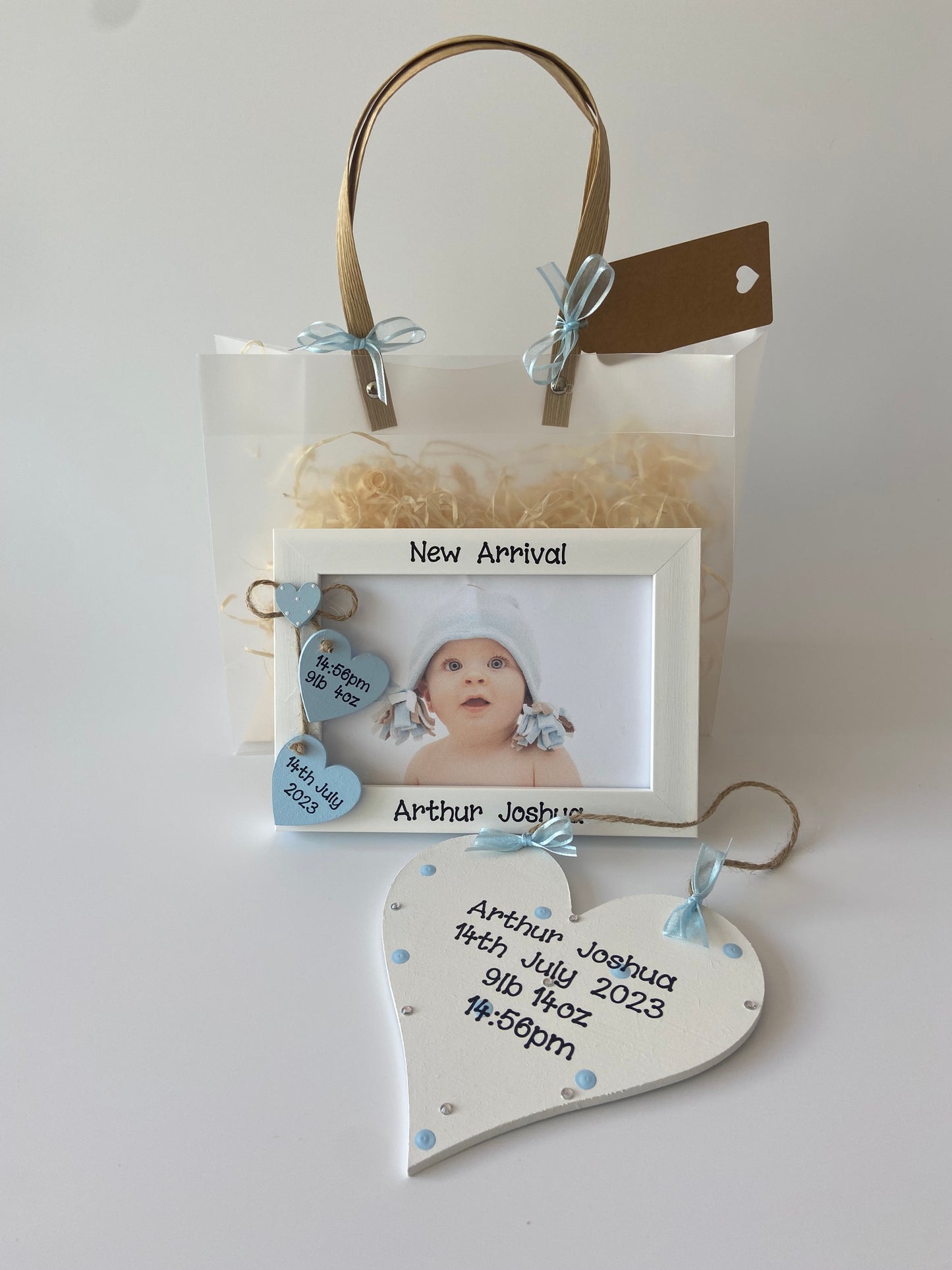 Image shows pairing new born baby photo frame and plaque, photo frame consists of two hanging hearts with baby's date of birth, time of birth and weight, also includes a small heart placed above with white polka dots. Plaque decorated with polka dots, gems and ribbon. Gift wrap and photo of ur choice also included.