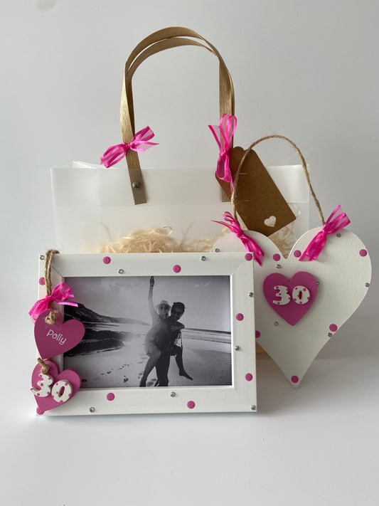 Image shows pink gift set for 30th birthday including a photo frame and plaque, with pink polka dots, gems and ribbon
