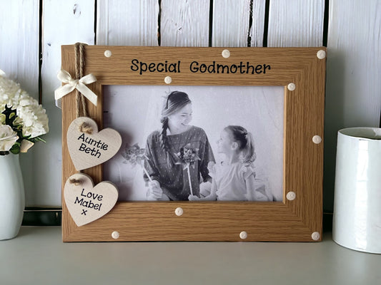 Image shows brown vintage special godmother photo frame, decorated with cream polka dots, attached are two hanging hearts for names with string and a cream bow.