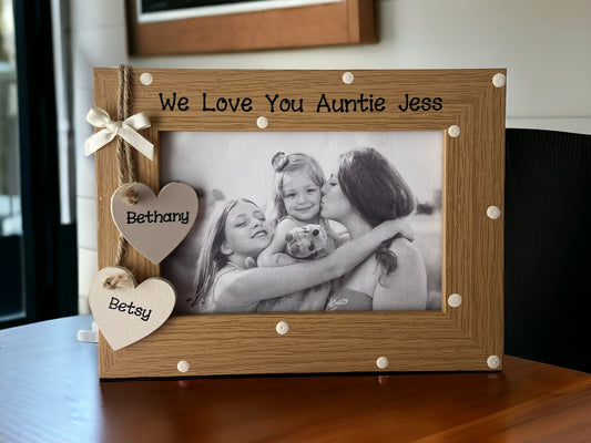 Image shows brown vintage photo frame, decorated with cream polka dots and two cream wooden hearts for names, attached to string and cream bow.