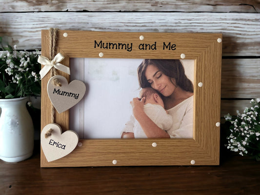 Image shows vintage brown mummy and me photo frame, decorated with cream polka dots with two cream wooden hearts attached for mum and child's name, above sits a cream bow.