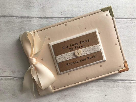 Image shows 6x4 photo album, decorated with beige polka dots and cream ribbon, also a cream plaque with dotted ribbon and a wooden heart, with quote and names printed on.