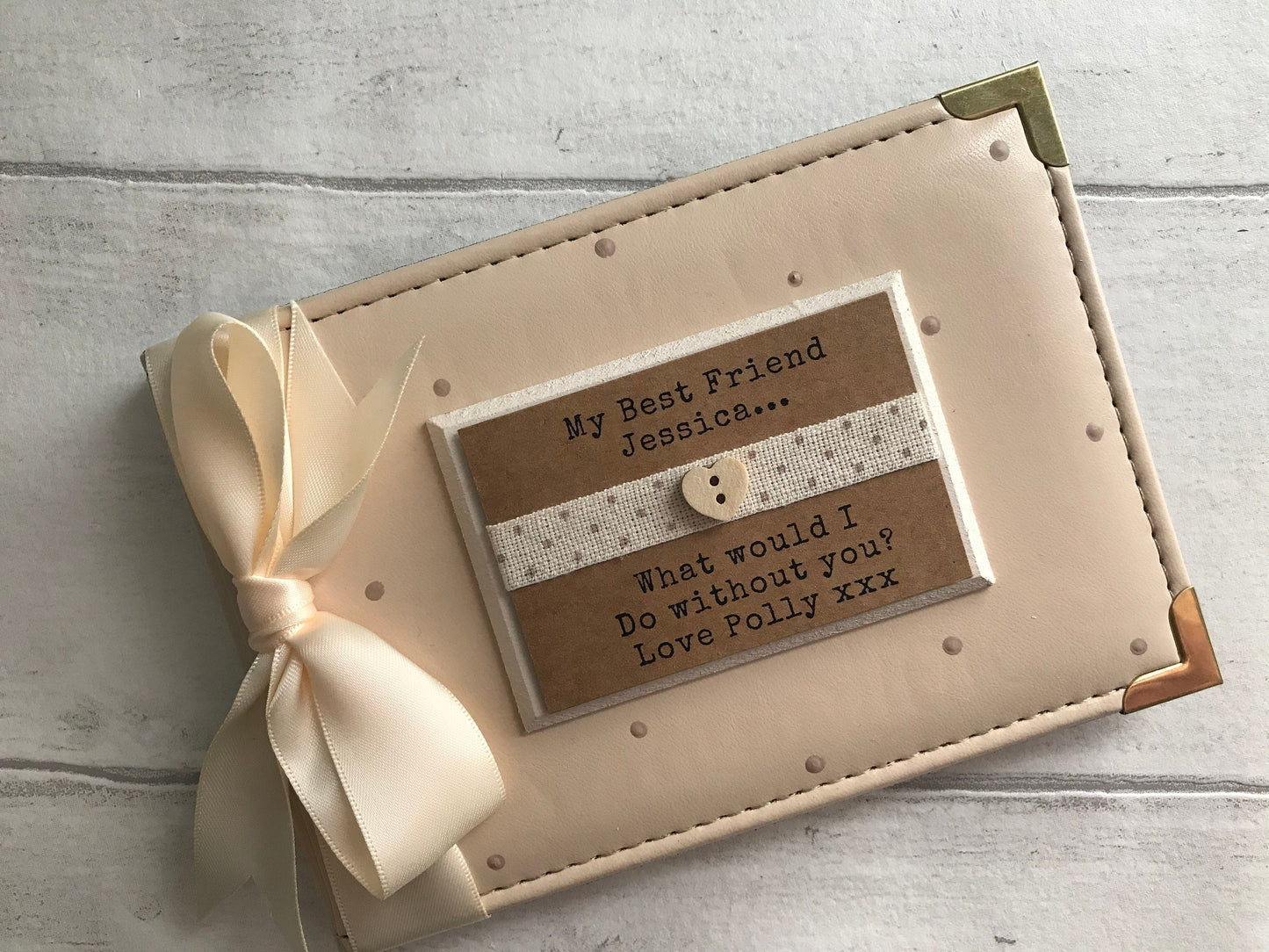 Image shows 6x4 friendship photo album, decorated with beige polka dots, cream ribbon, cream plaque with dotted ribbon and a small wooden heart, text and names added to plaque.