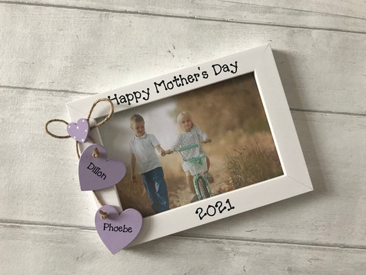 Image consists of mothers day photo frame, including hanging hearts with children's names and a smaller heart sat above.